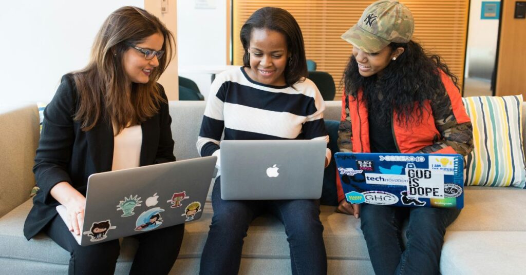 Three girls are sitting together and going through a collaborative learning