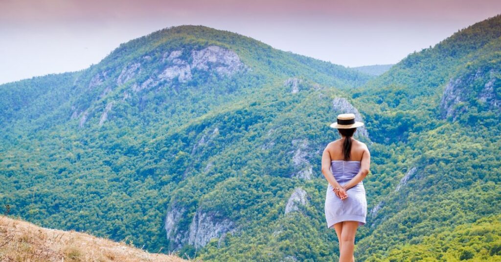 An image of a lady who is looking to the mountains. It shows the positive thinking.